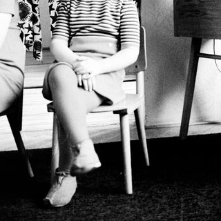 Black and white photo of a young girl sitting on a chair.