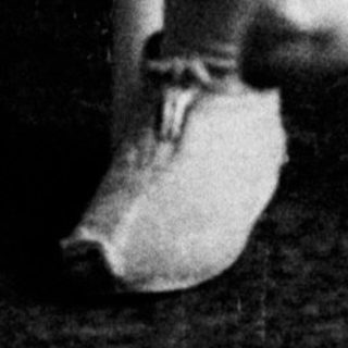 Black and white photo of a young girl sitting on a chair.