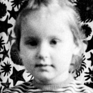 Black and white photo of a young girl sitting on a chair.