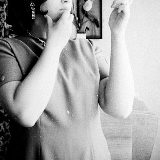 Woman looking in a mirror, examining her face.
