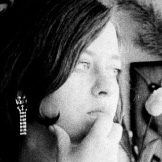 Woman looking in a mirror, examining her face.