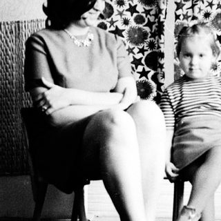 Woman and child seated, posing for a black and white portrait.