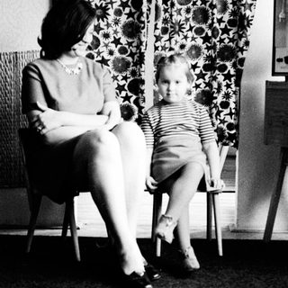 Woman and child seated, posing for a black and white portrait.