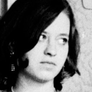 Woman and child stand in a room, looking apprehensive.