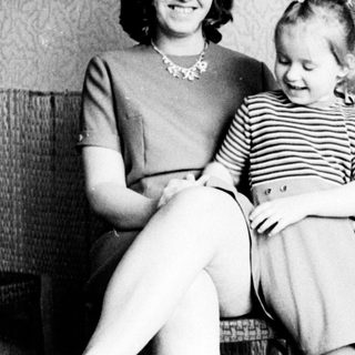 Woman and child seated indoors, black and white photography.