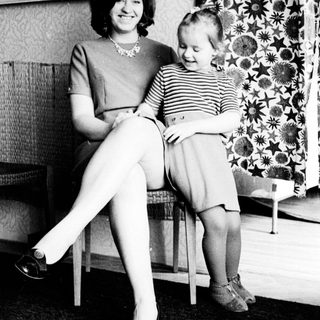 Woman and child seated indoors, black and white photography.
