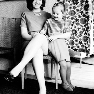 Woman and child seated indoors, black and white photography.