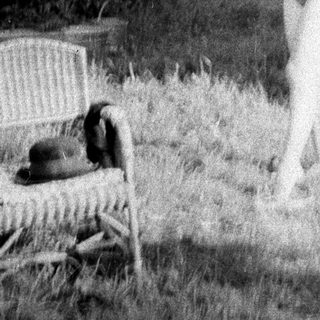 Woman playfully tossing a plate in a grassy yard.