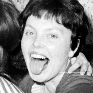 Group of women playfully sticking out their tongues.