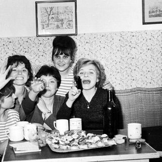Group of women smiling and posing at a table.