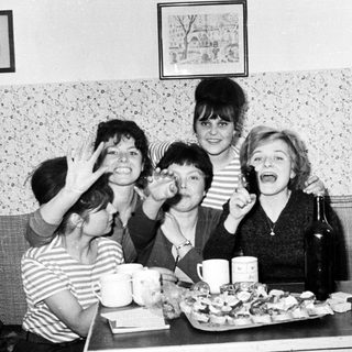 Group of women smiling and posing at a table.