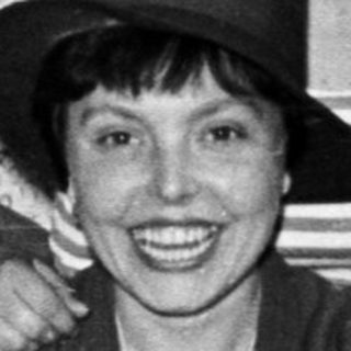 Group of women playfully wearing hats and smiling.