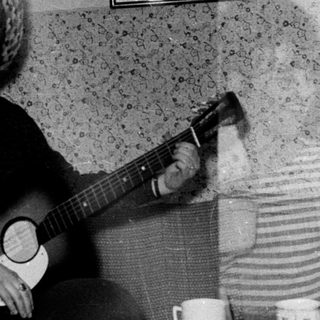 Musicians playing instruments in a room with textured walls.