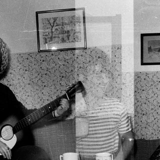 Musicians playing instruments in a room with textured walls.
