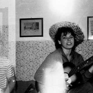 Musicians playing instruments in a room with textured walls.
