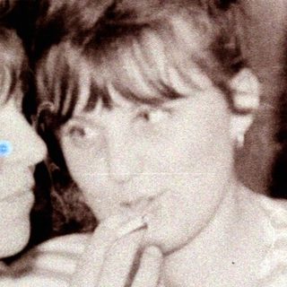 Two girls in striped shirts, looking towards something off-camera.