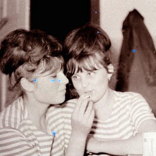 Two girls in striped shirts, looking towards something off-camera.
