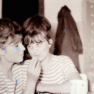 Two girls in striped shirts, looking towards something off-camera.