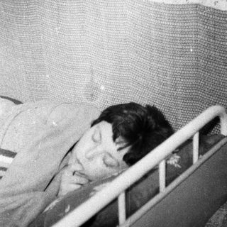 Here's a brief summary: Baby sleeping in a crib, appearing peaceful and still.