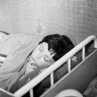 Here's a brief summary: Baby sleeping in a crib, appearing peaceful and still.
