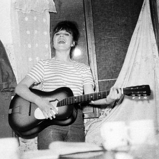 Black and white photo of a person playing a guitar.