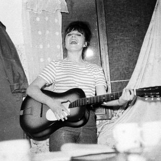 Black and white photo of a person playing a guitar.