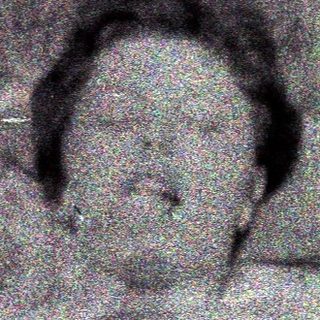 Here's a brief summary of the image: Person lying on ground, appearing distressed, in an outdoor setting.