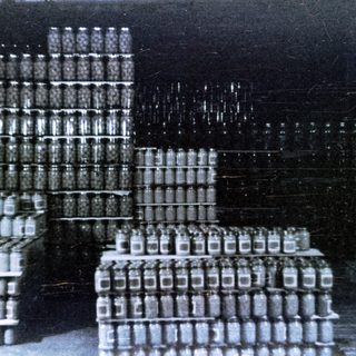 Stacked jars or bottles in a warehouse or storage area.