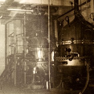 Industrial machinery in an aged, dimly lit factory setting.