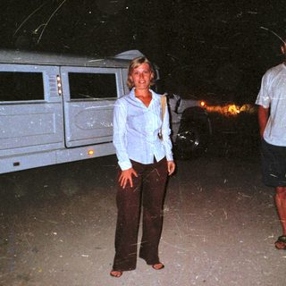 People standing near a camper van at night.