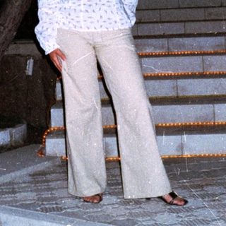 Woman stands on stone steps at night, outdoors.