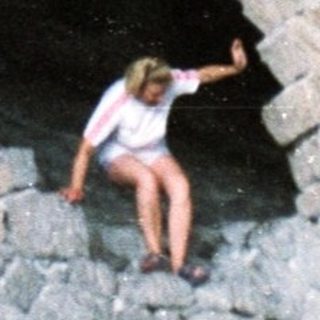 Stone structure with a person inside and one outside.