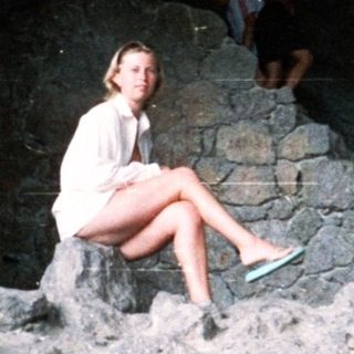 People relax within an arched, stone structure.