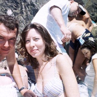 Group of people posing for a photo with a mountain backdrop.