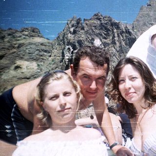 Group of people posing for a photo with a mountain backdrop.
