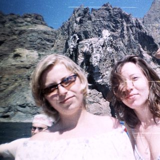 People on a boat with a mountain backdrop.