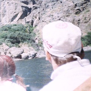 People view a river with steep, rocky cliffs.