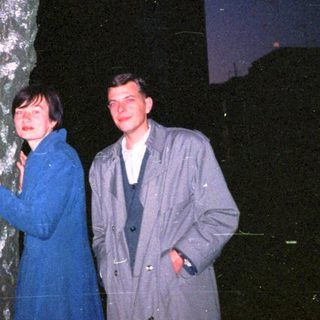 Family posing outdoors near a tree at night.