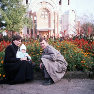 Family poses outdoors in front of an ornate building.