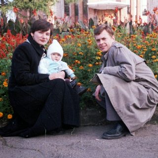 Family poses outdoors in front of an ornate building.