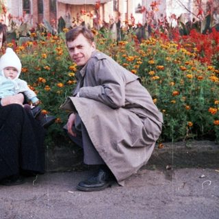 Family poses outdoors in front of an ornate building.