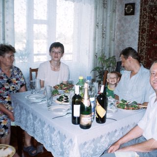Family seated at a table with food and drinks.