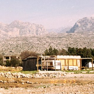 Buildings and structures in a landscape with mountains.