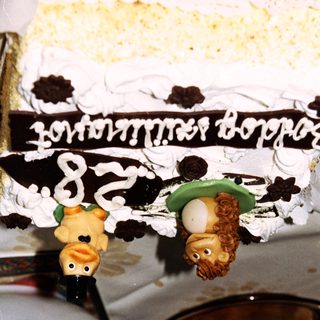A decorated cake with animal figurines and celebratory inscription.