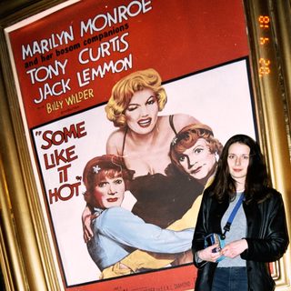 Woman stands before "Some Like It Hot" movie poster.