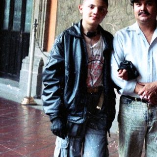 People pose near a mural in a building hallway.