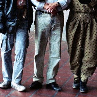 People pose near a mural in a building hallway.