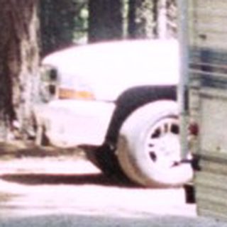 Man stands near a vintage camper van in a campsite.