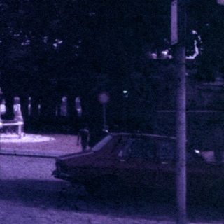 Vintage image shows architecture, street, and people in a city.