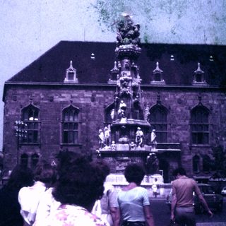 People view a fountain in front of a building.